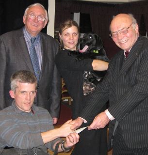 Dogs for the Disabled user Darren Brook receives at cheque from club president David Pickover. With them are Rotarian Roger Cressey, Rowan Martin and Millie